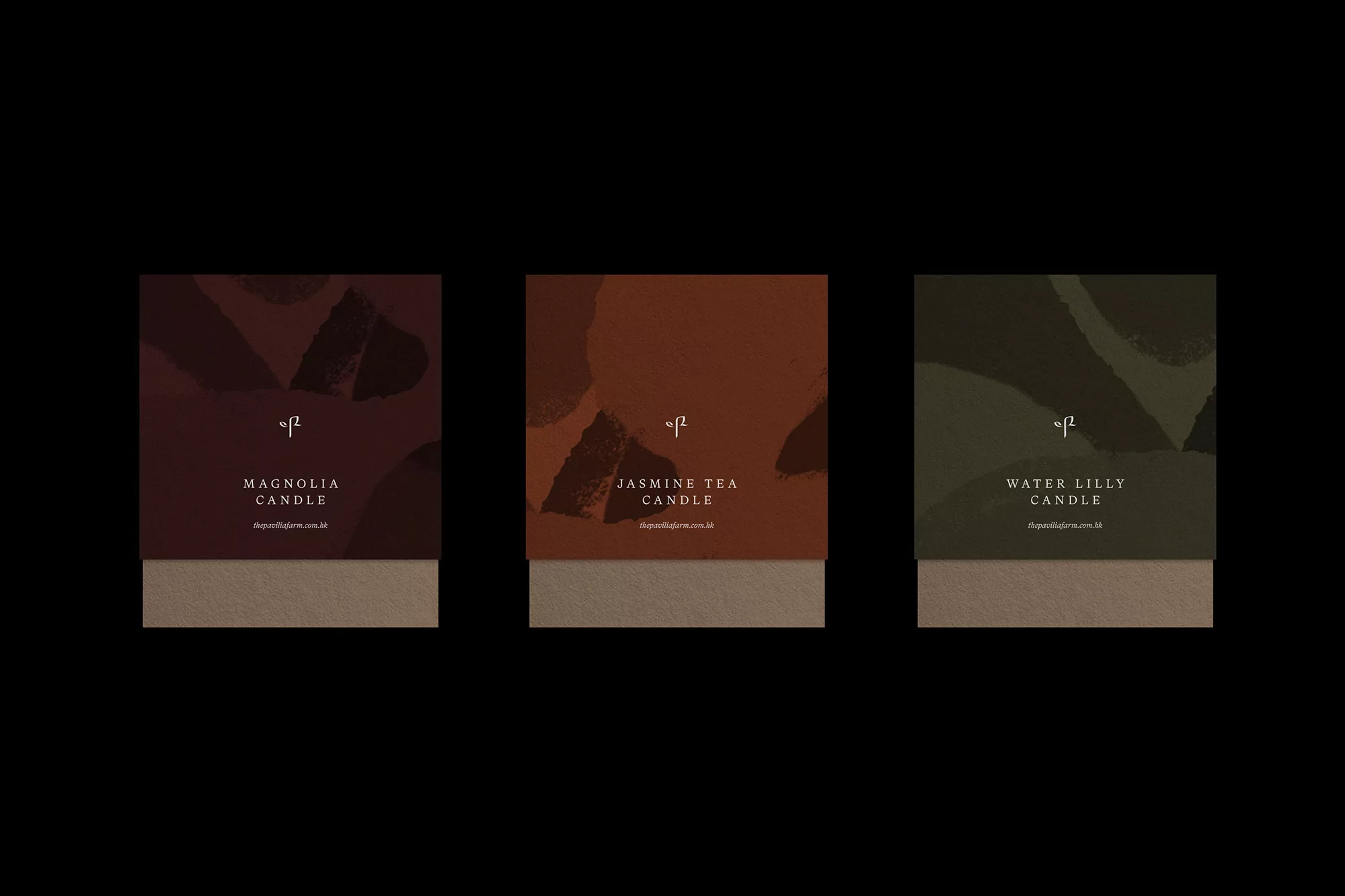 Three candles with labels are displayed against a dark background, with each label having its unique color and name.