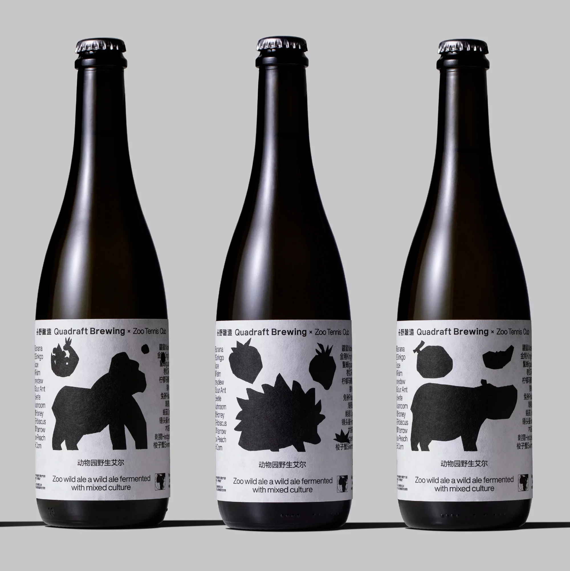 Three dark glass bottles of Quadraft Brewing Zoo wild ale with labels featuring animal silhouettes on a neutral background.