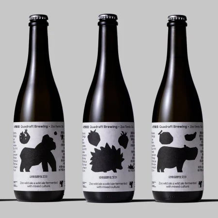 Three dark glass bottles of Quadraft Brewing Zoo wild ale with labels featuring animal silhouettes on a neutral background.