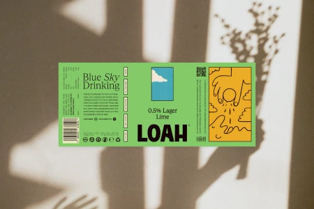 Loah Beer Co. lime beer label on a beige surface with soft shadows and botanical silhouette