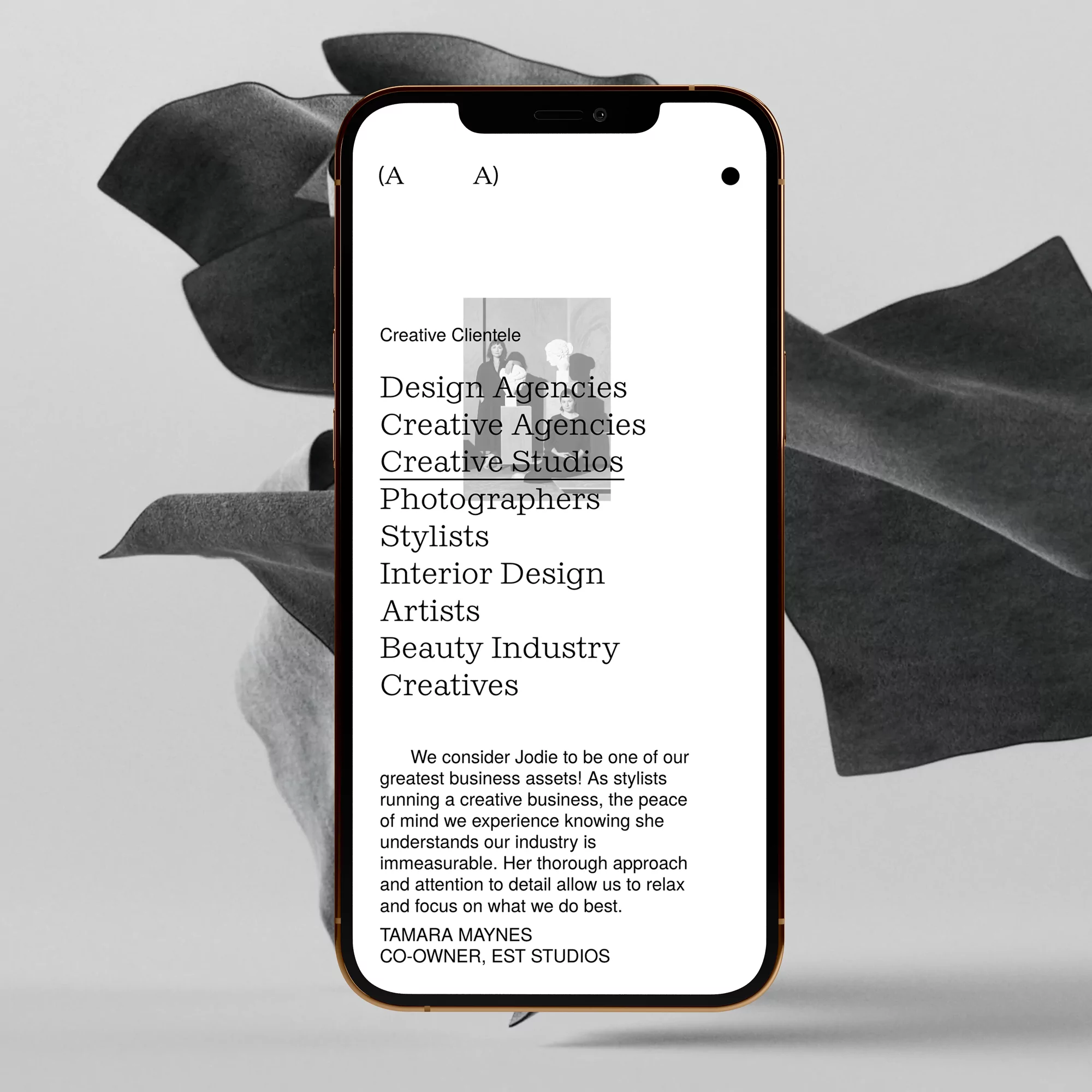 Smartphone displays creative agency list: design, creative studios, stylists, interior designers, artists, beauty industry, creatives.