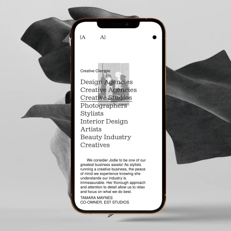 Smartphone displays creative agency list: design, creative studios, stylists, interior designers, artists, beauty industry, creatives.