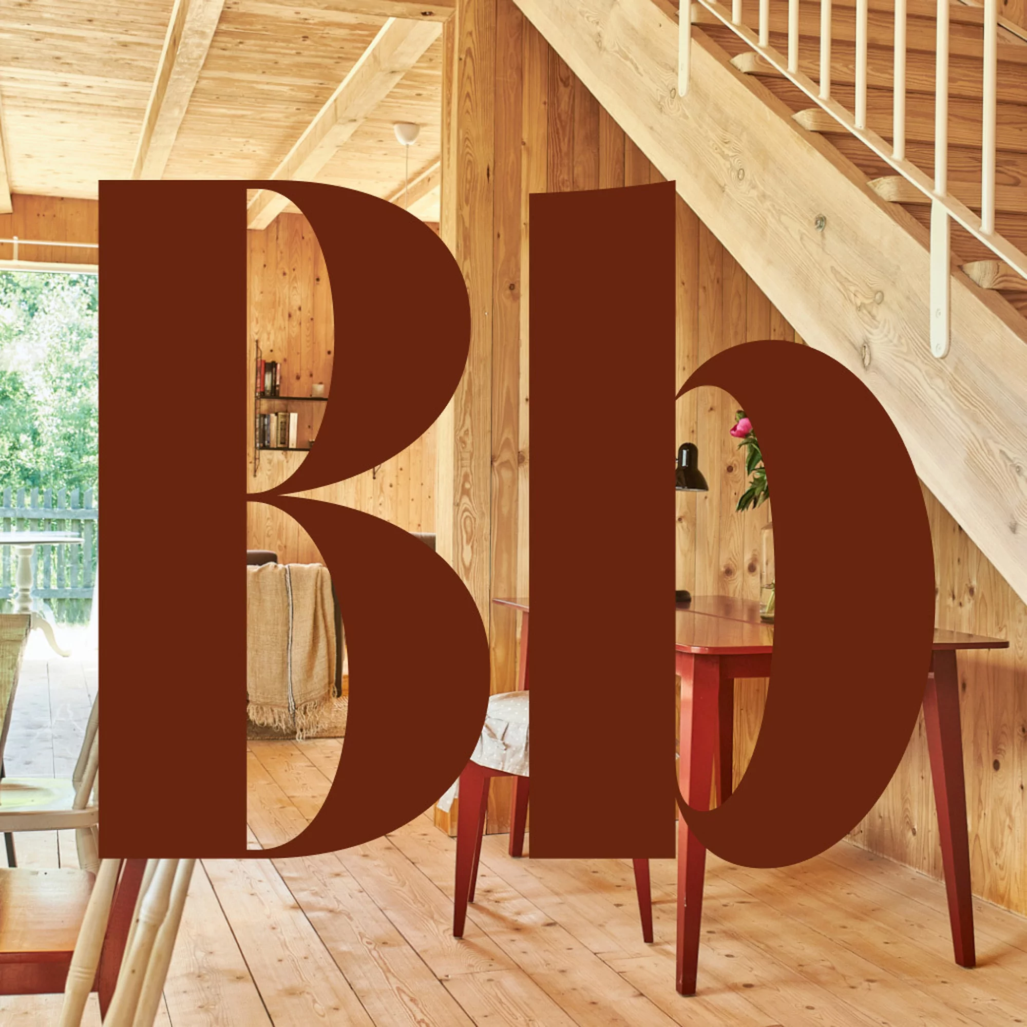 Interior of a wood-paneled home featuring a red table and chairs, wooden stairs, and large brown graphic text overlay.