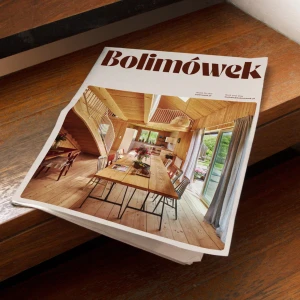 Printed publication with Bolimowek branding resting on a polished dark wood surface showcasing interior architecture photography