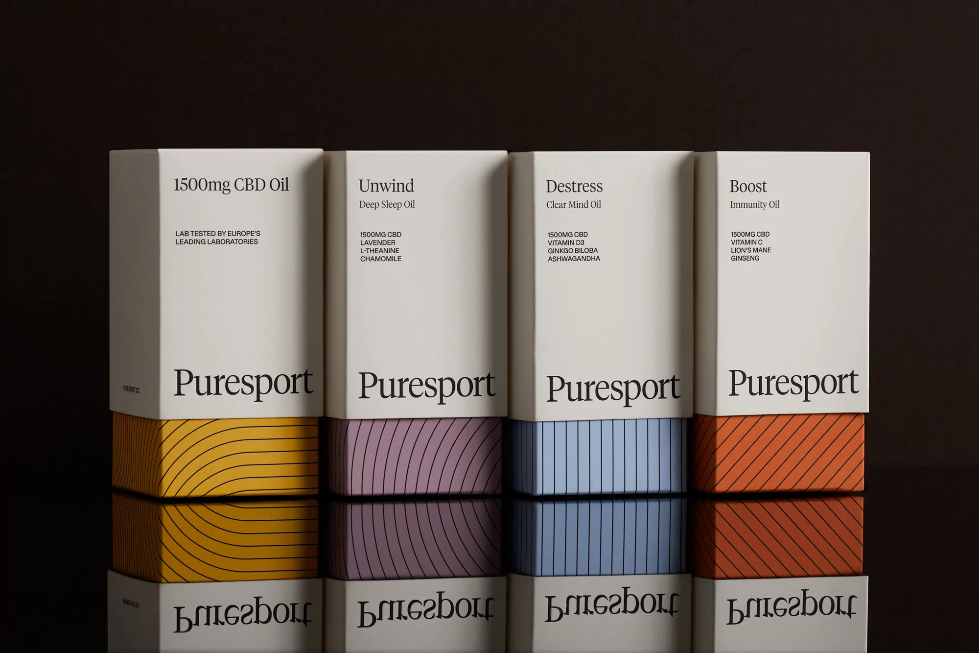Four PureSport CBD oils in boxes: Unwind, Destress, Boost, and Immunity. The products sit on a reflective black surface against a dark backdrop.