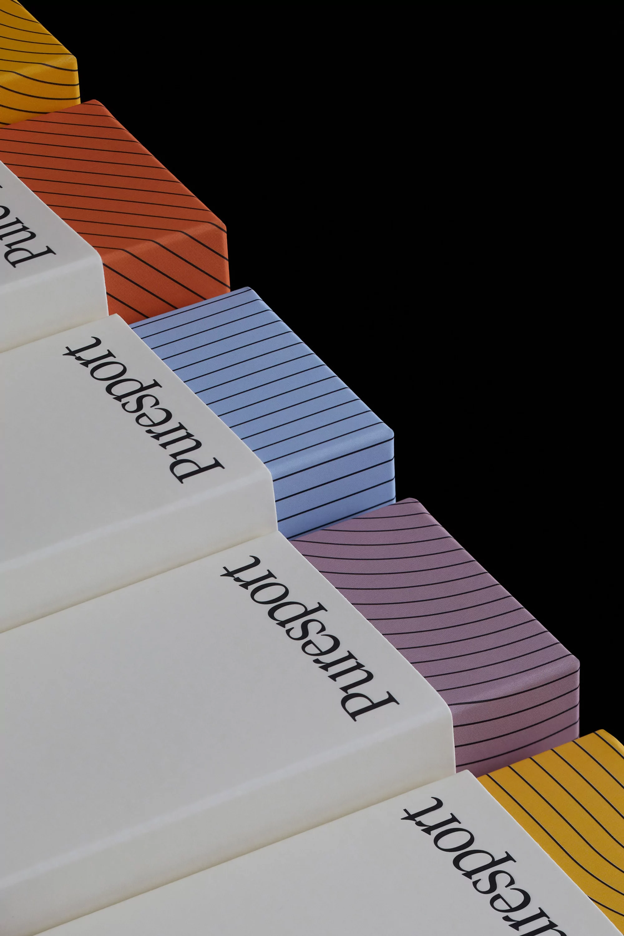 Stack of colorful, patterned boxes with 'puresport' logo against a black background in eye-level studio shot. Product photography.