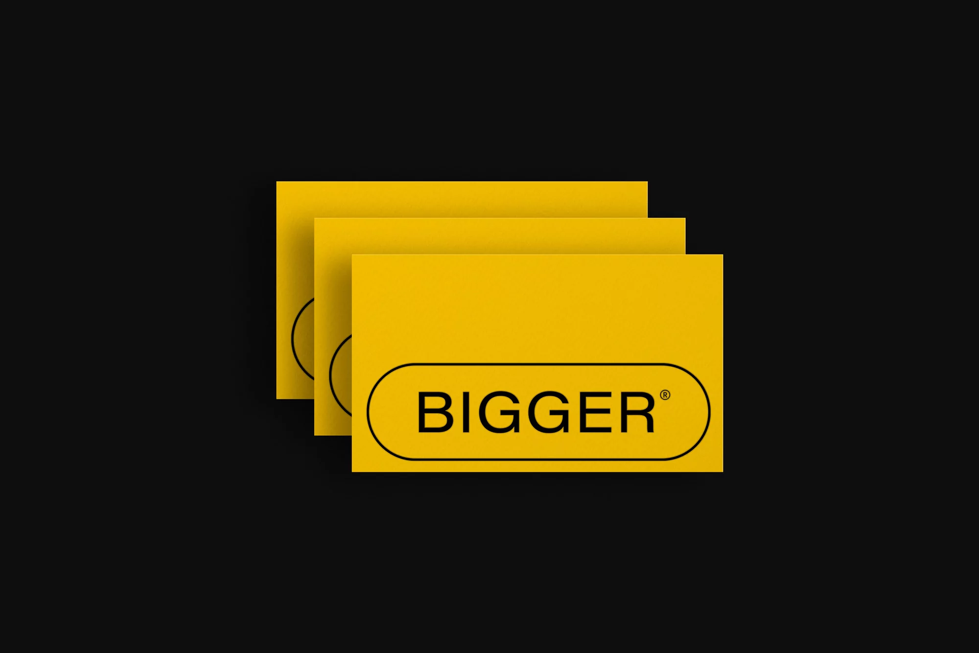 Overlapping yellow cards displaying the text 'Bigger' in black on a dark background, suitable for business or promotional materials.