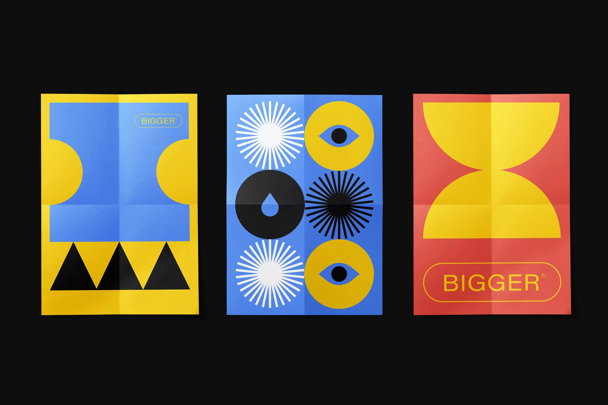 Three folded posters on a black background, each featuring geometric shapes in yellow, blue, black, white, and red with the word 'BIGGER'.