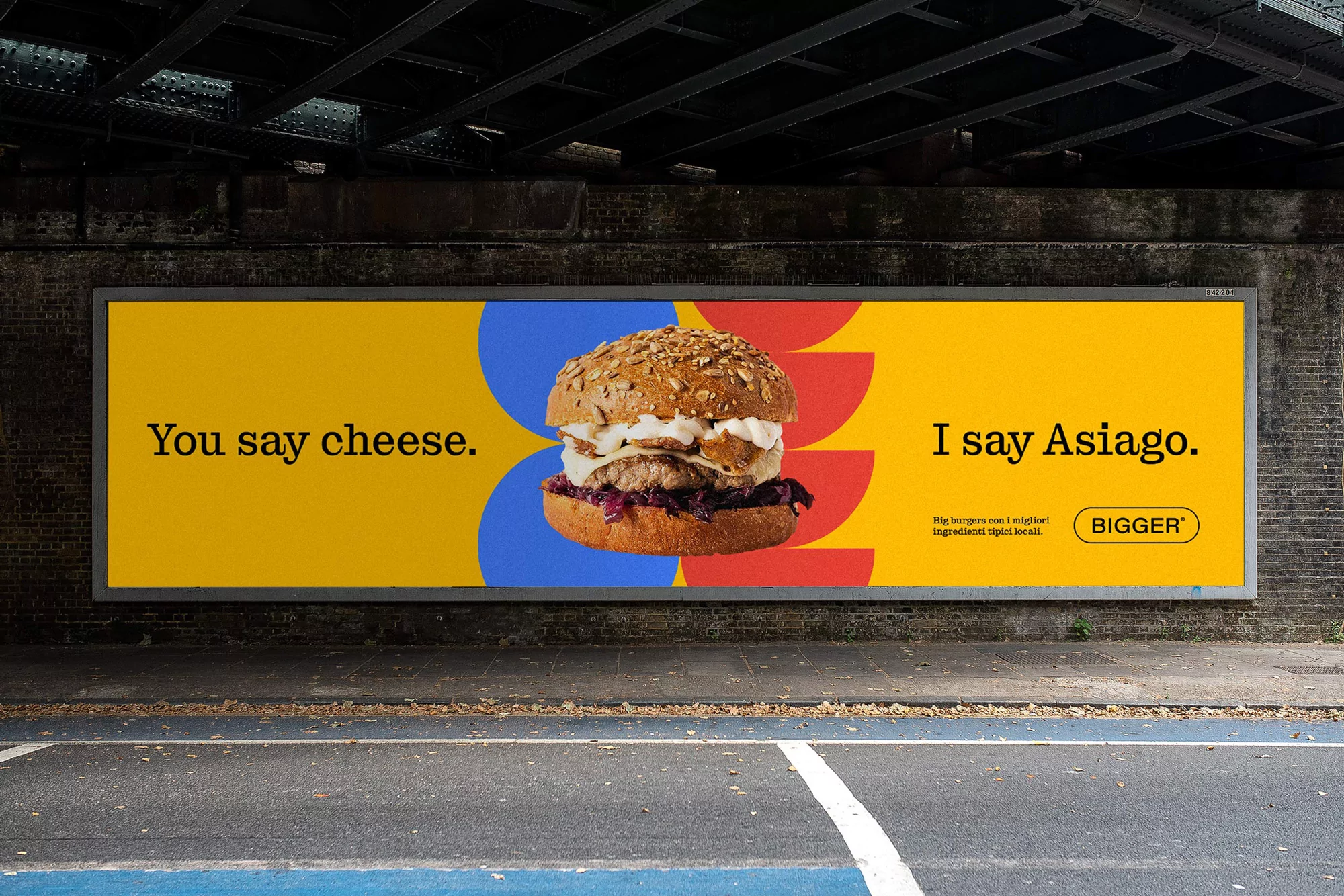 Billbord advertisement for Bigger Burgers featuring a large gourmet burger on a vibrant yellow background with typography.
