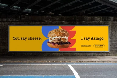 Billbord advertisement for Bigger Burgers featuring a large gourmet burger on a vibrant yellow background with typography.