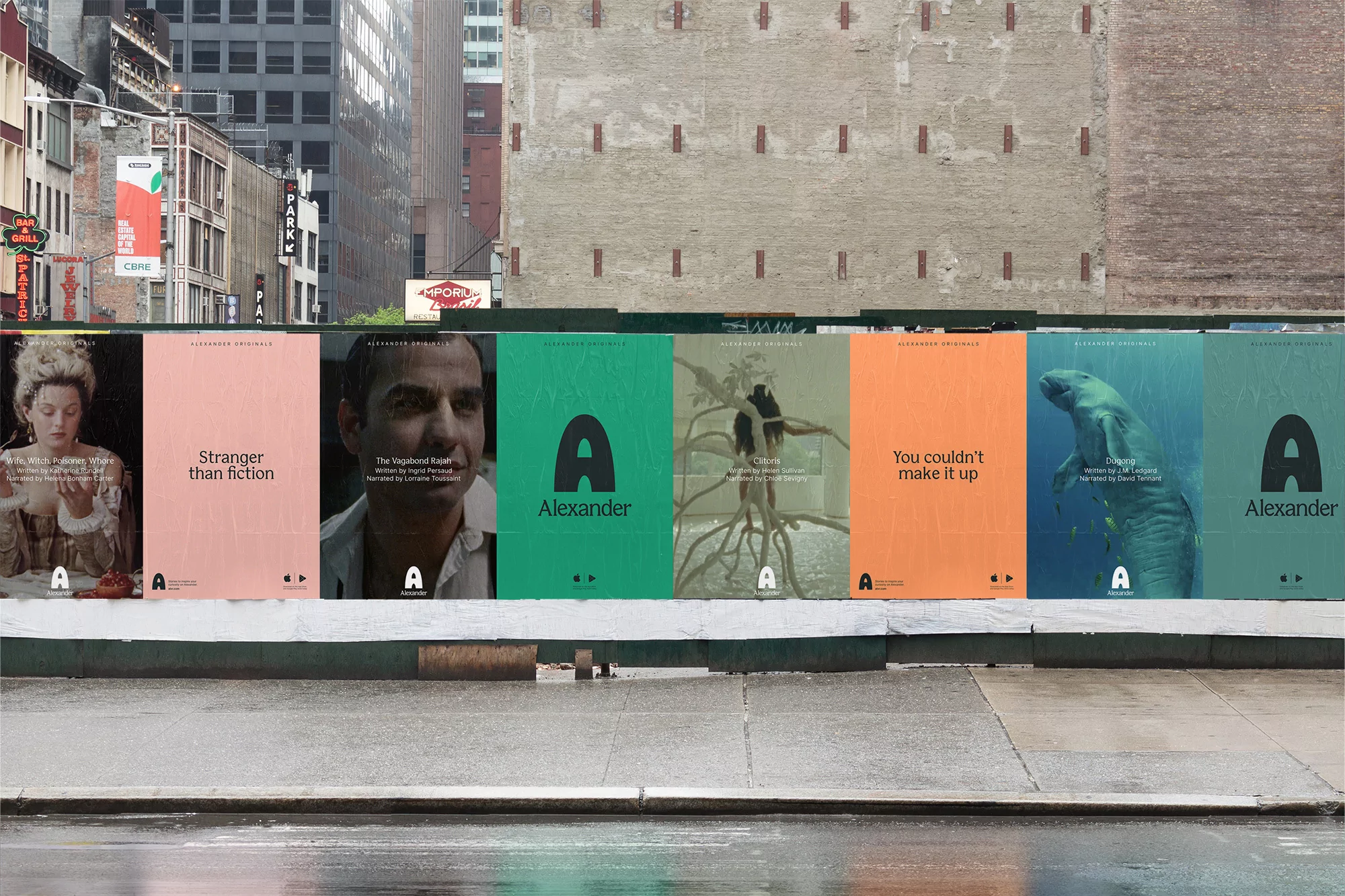 Outdoor billboard display on an urban street featuring a series of posters in various colors with the letter A and different scenes.