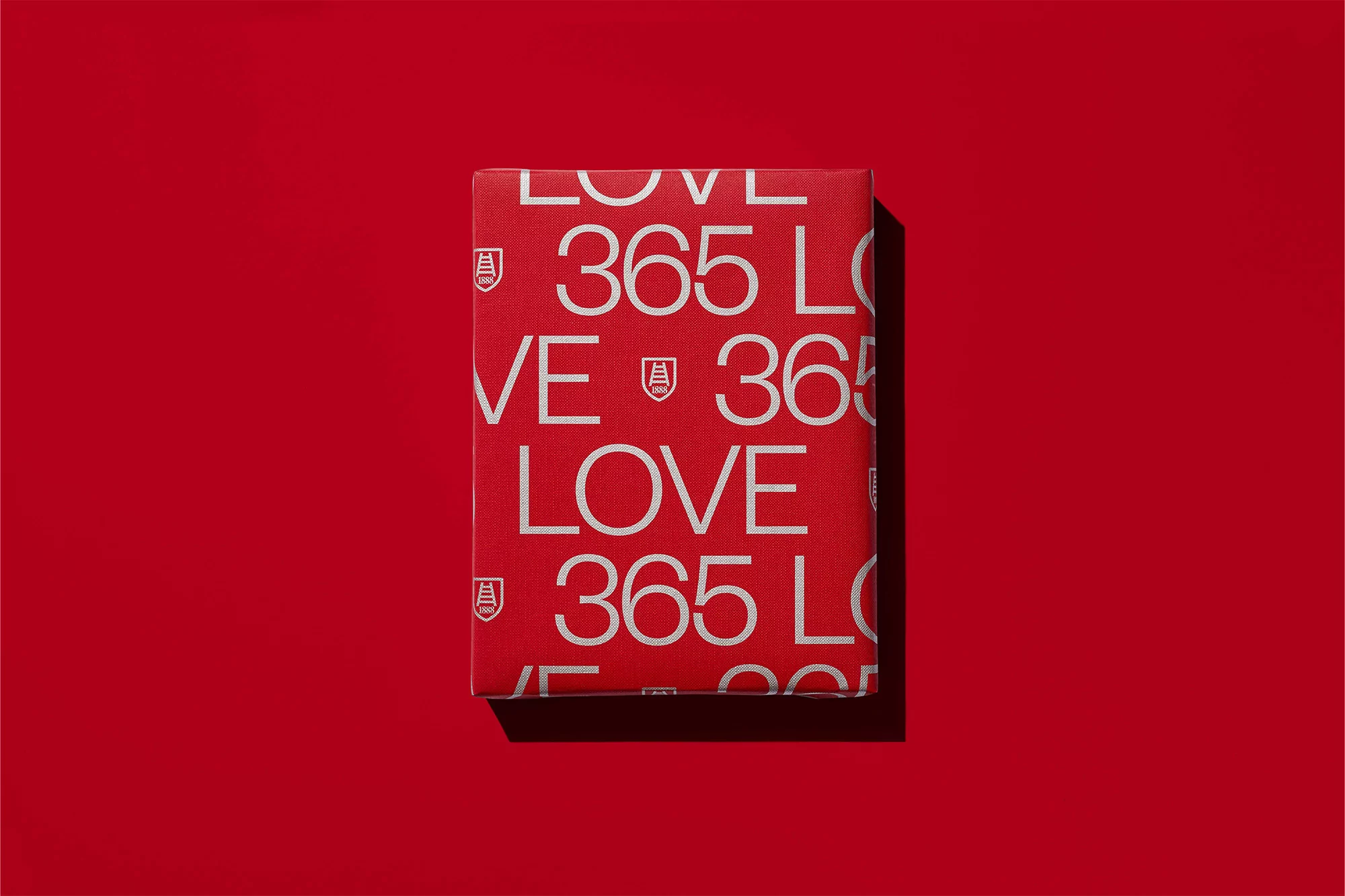Red gift box with 'LOVE' and '365' text design, centered on a red background, suitable for product promotion or festive greetings.
