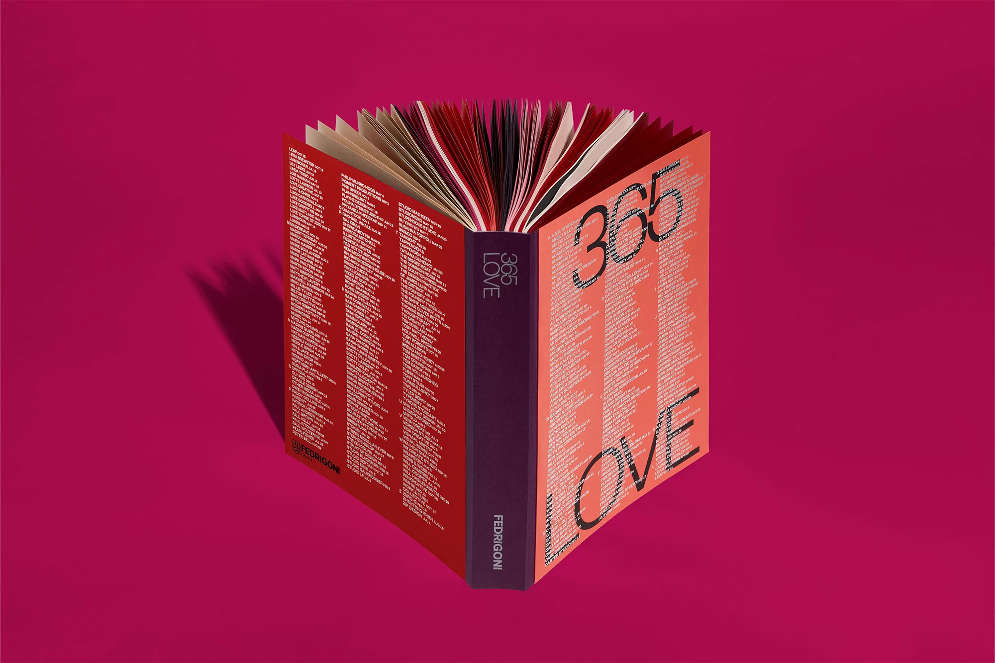 Close-up of an open book with red, pink, and black pages against a bright pink background. The book's title is '365 Love'.