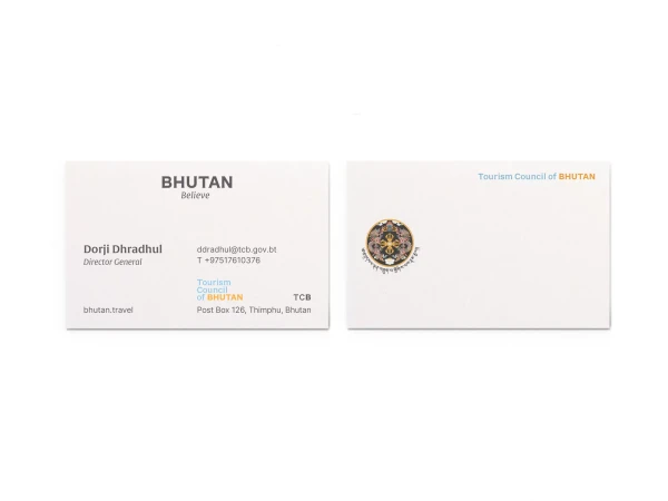 Two business cards with Bhutan Tourism Council branding, contact information, and official logos. One card features Dorji Dhradhul's details.