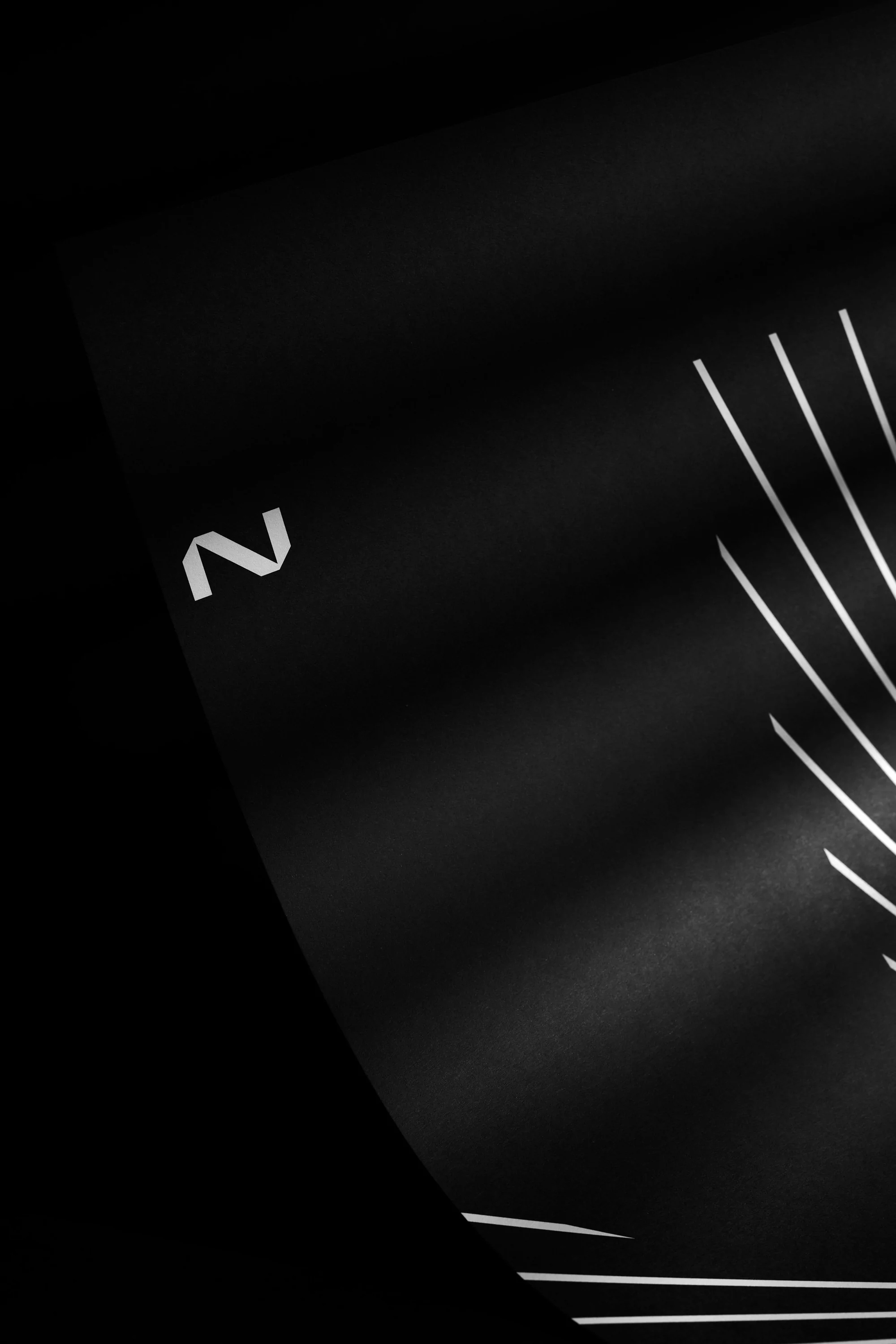 Abstract dark background with diagonal white lines and soft lighting, creating a minimalist and modern composition.