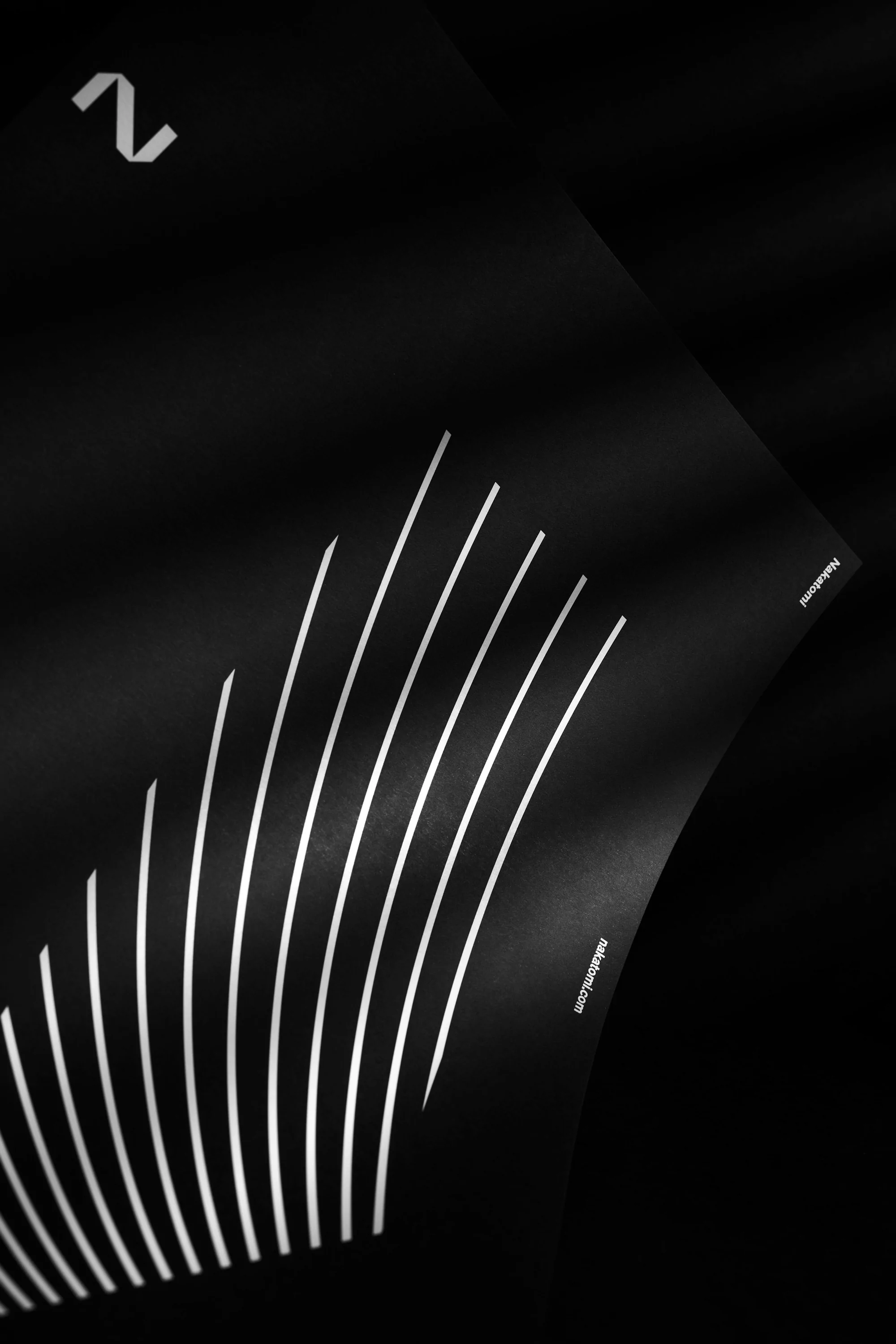 Black paper with white lines and the number 2, creating an abstract, minimalist composition in a dark, graphic design aesthetic.