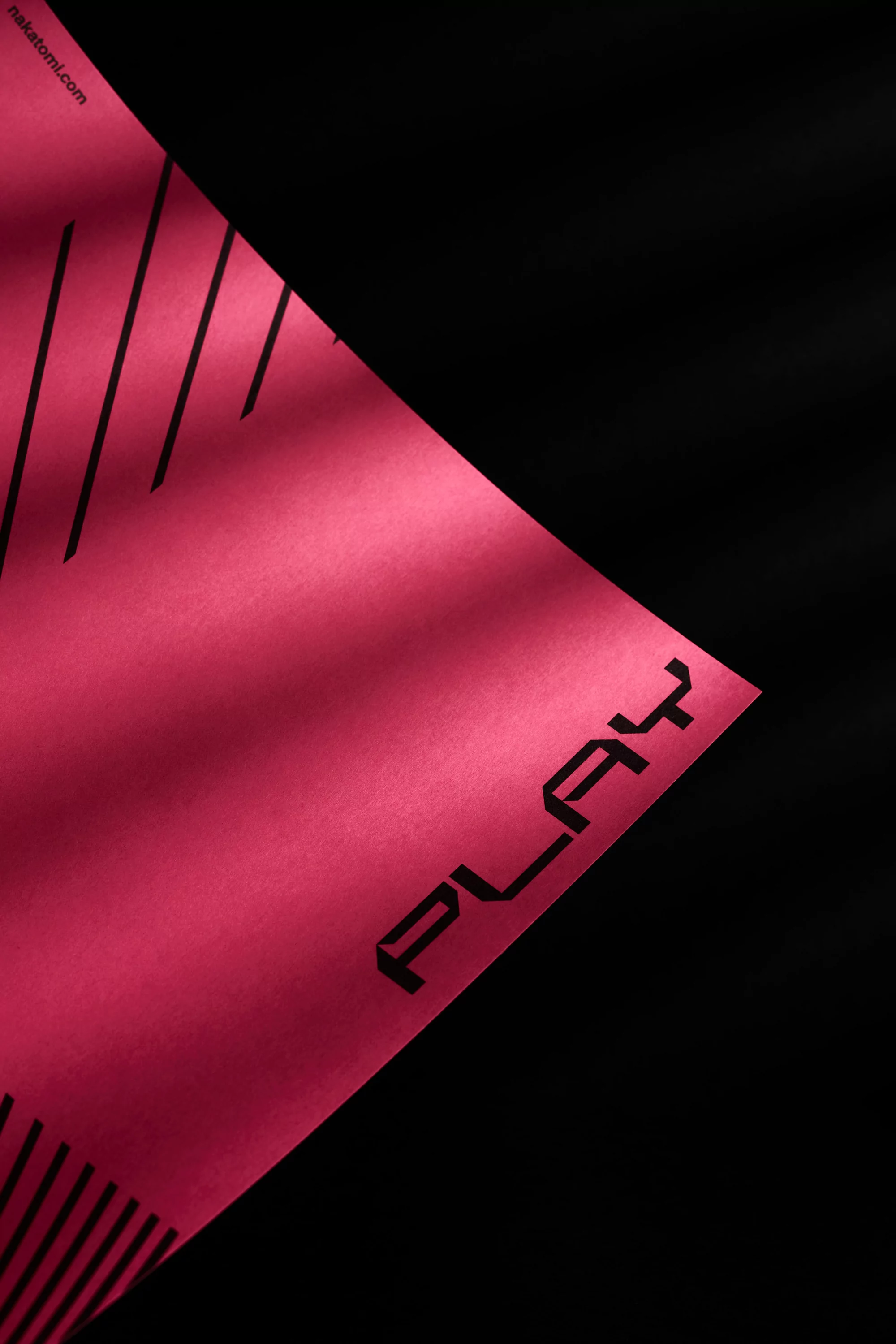 Abstract product background featuring a textured red surface with dark geometric lines and the word 'PLAY' against a black backdrop.