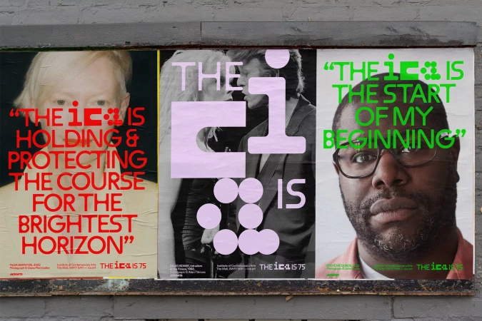 Eye-level shot of three artistic posters attached to a wall, featuring portraiture, vibrant text, and abstract designs in an urban environment.