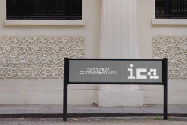Signage for the Institute of Contemporary Arts displayed in front of a classical building exterior with ornate wall panels.