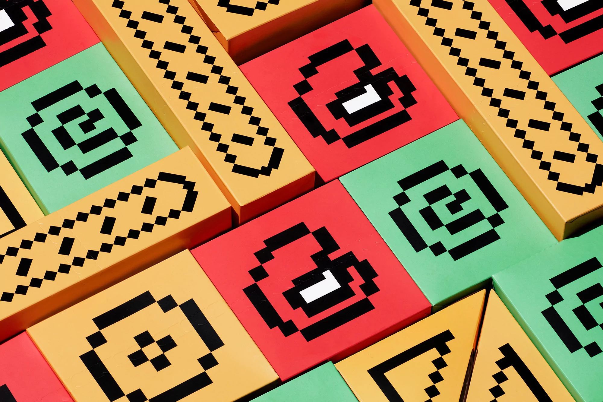 Overhead studio shot of colorful square and rectangular blocks arranged in a geometric pattern with pixelated designs on each block.