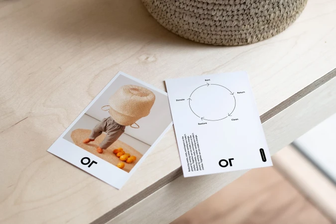 Photograph of a printed image showing a person with a basket on their head, alongside a circular diagram on a table with a woven basket.