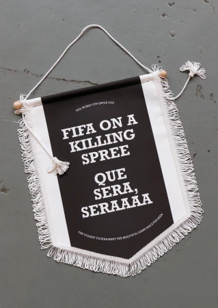 Hanging black and white banner with fringe and graphic text about FIFA on a gray background.