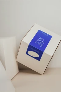 White cake box with a blue brand label reading six inch cake on a neutral surface