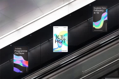 Anthony Burrill brand identity posters displayed along a dark escalator wall in an architectural interior.