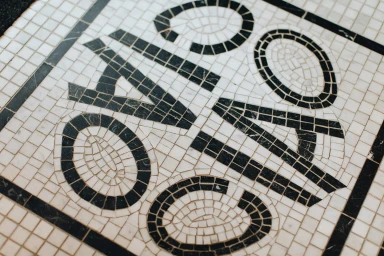 Close-up of a black and white tiled mosaic floor featuring decorative typography spelling words in custom lettering.