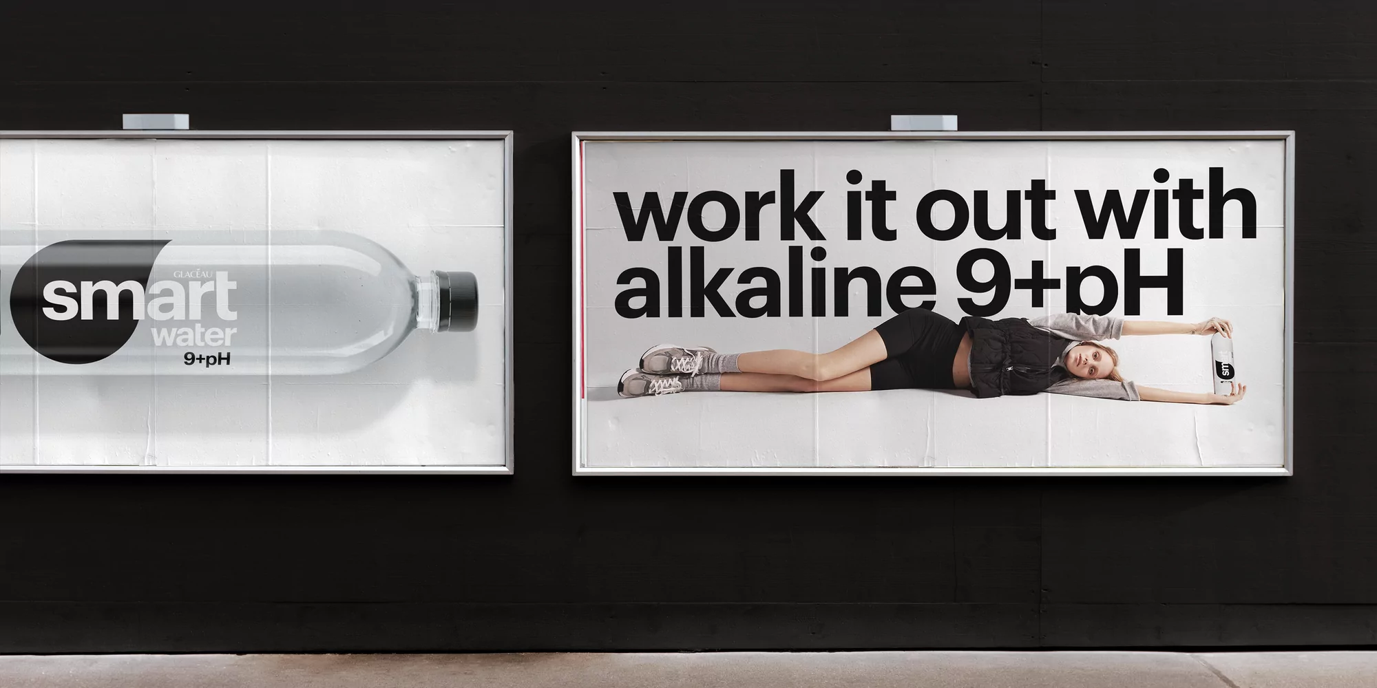 A billboard advertisement for Smartwater features a woman lying down next to the tagline 'work it out with alkaline 9+pH'.