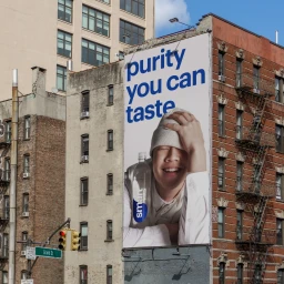 Large outdoor advertising billboard for smartwater mounted on a brick building facade in an urban street setting.