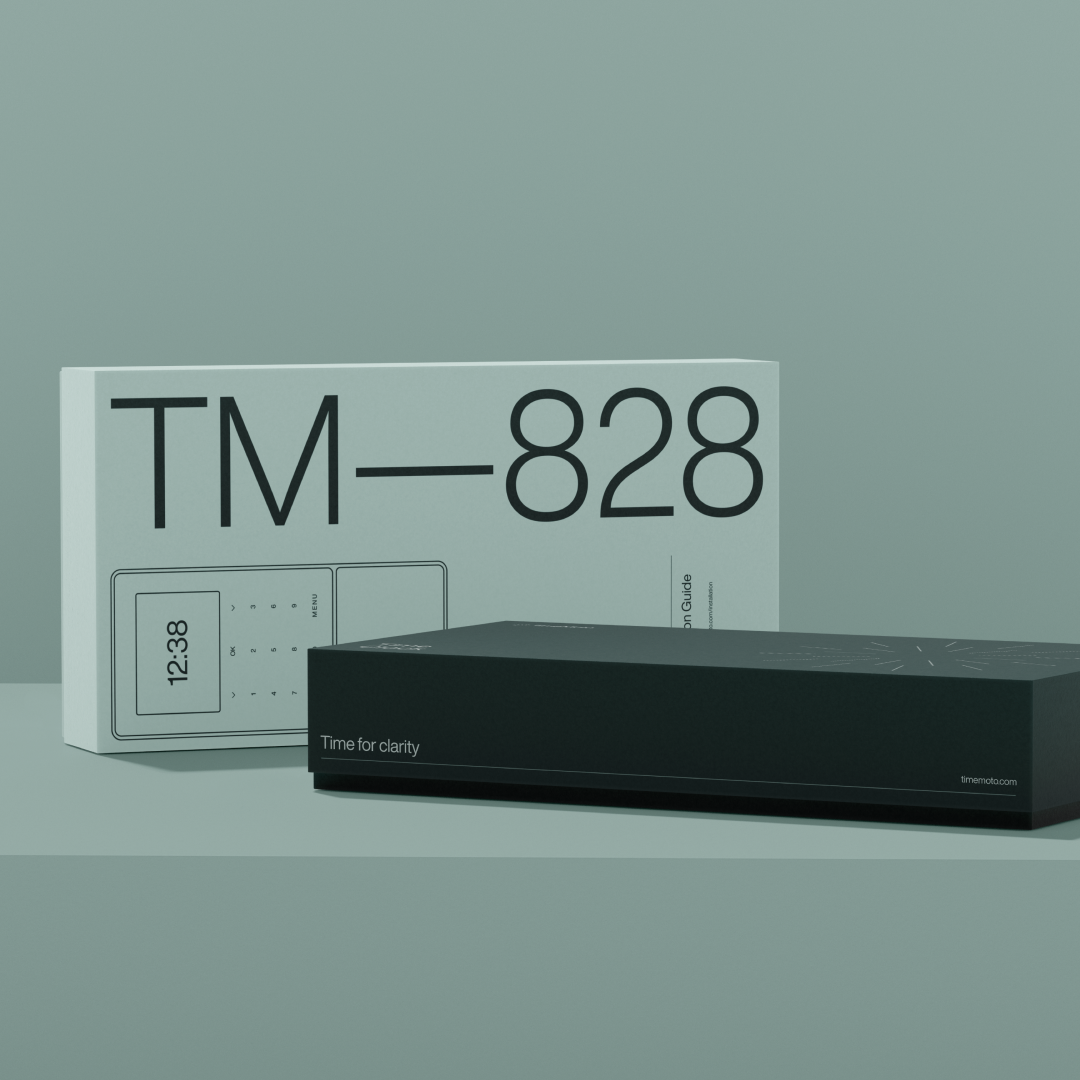 Product shot featuring a black electronic device box with a white box behind it, both on a muted green surface.