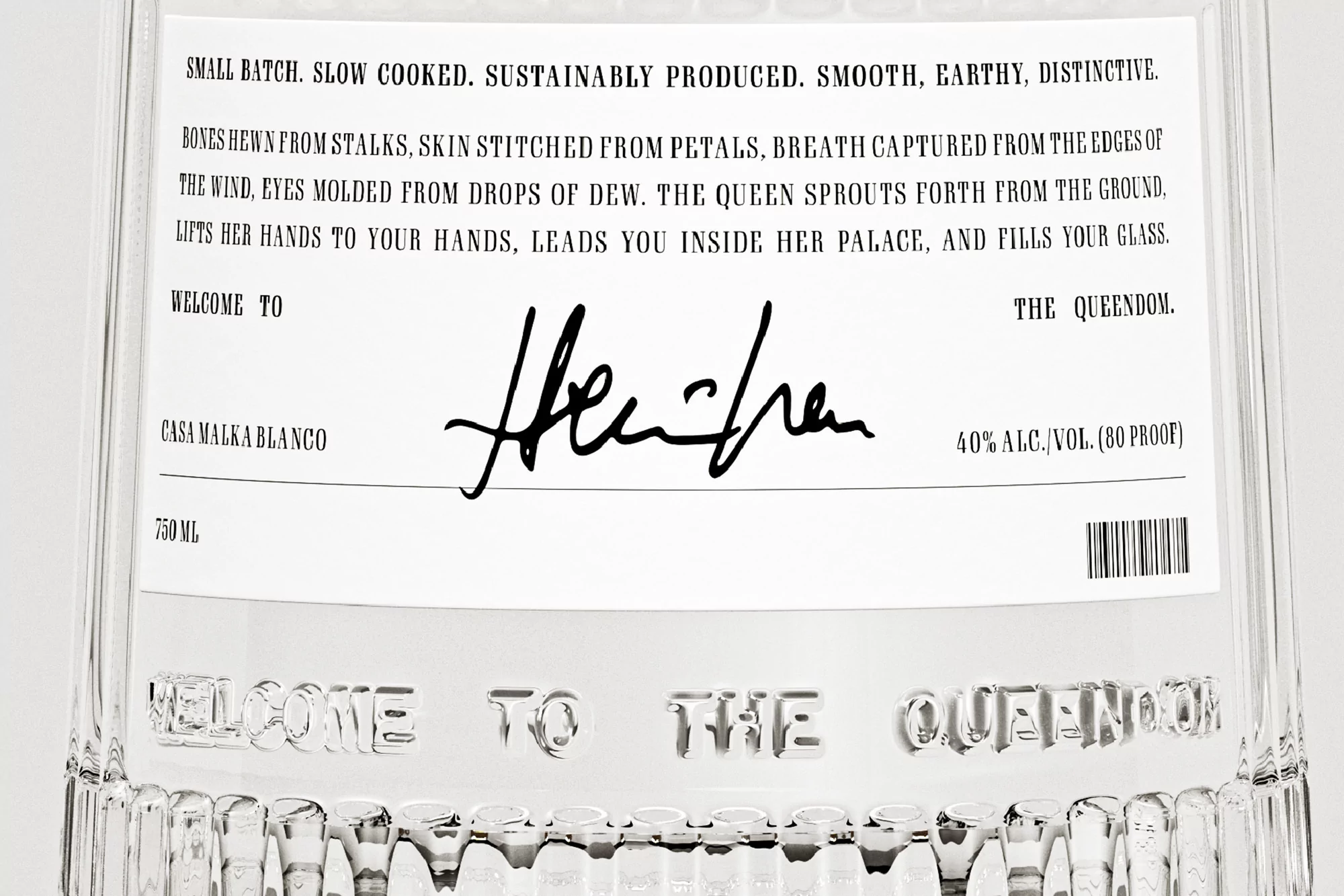 Close-up of a clear glass bottle featuring a white label with black text, showcasing the product name Casa Malka Blanco and decorative script.