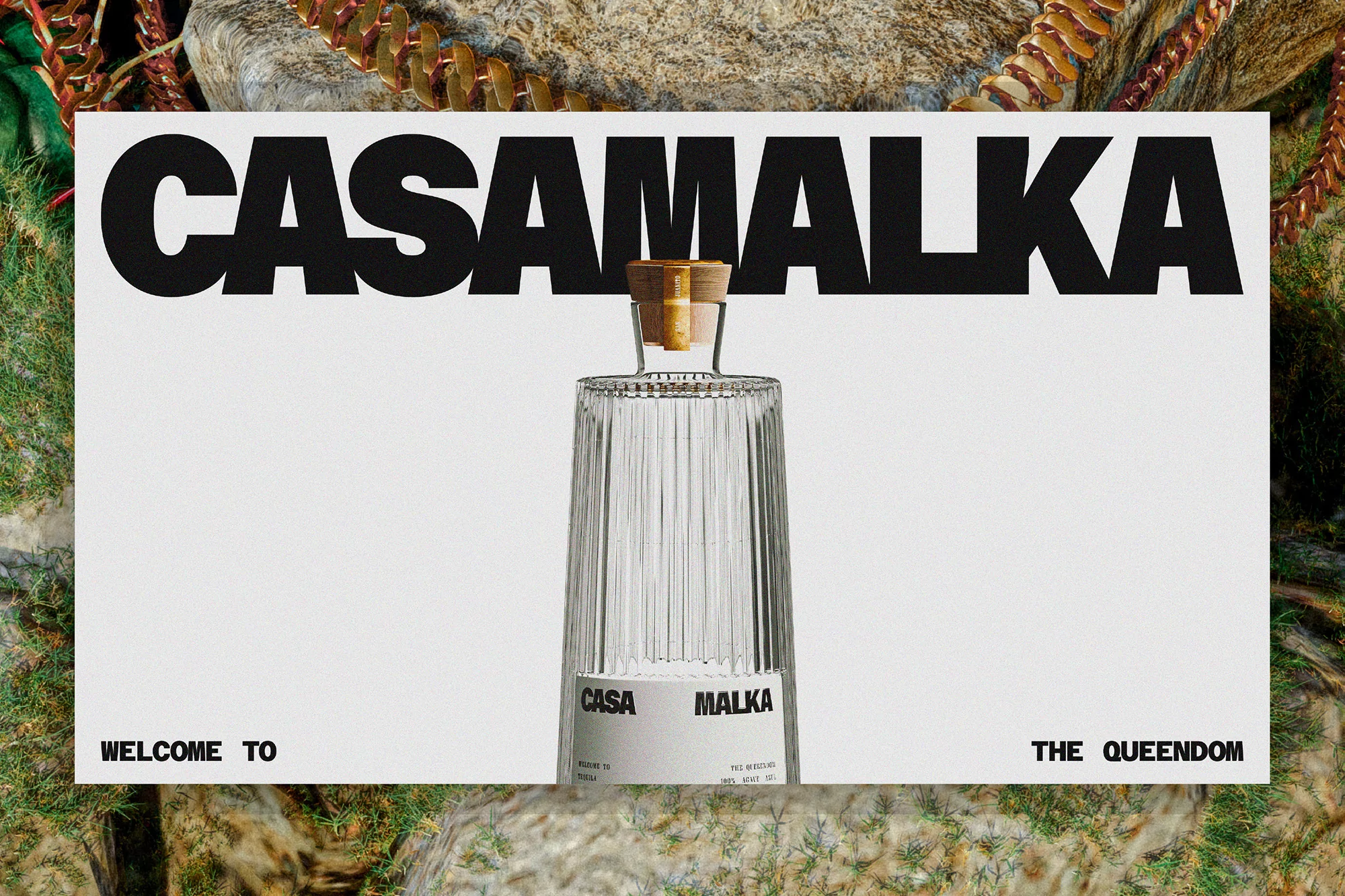 Product shot of a clear glass bottle with a cork stopper, branded with 'CASA MALKA', set against a textured white backdrop.