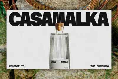 Glass bottle with a cork stopper centered in a white rectangular frame featuring bold black typography set against a rocky background