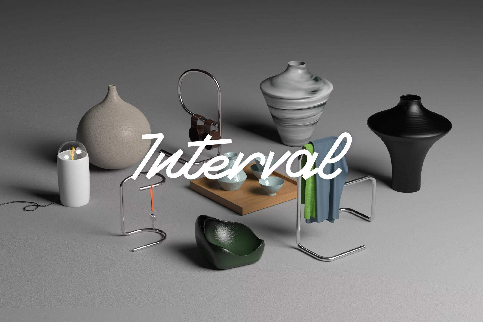 Still life of ceramic vases and bowls in neutral and dark tones arranged on a gray surface, lit with soft, diffused lighting.