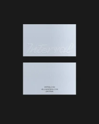Two white textured business cards with debossed script typography displayed against a solid dark grey background.