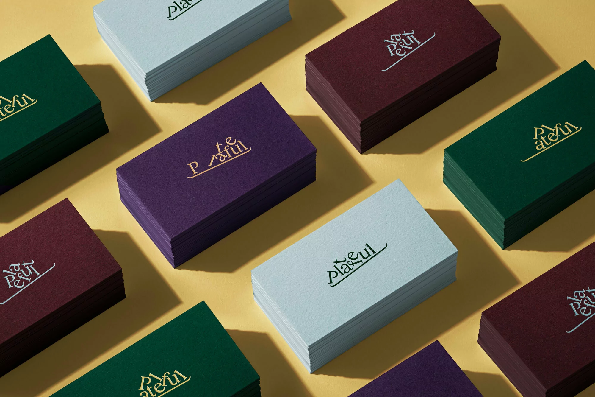 Stacks of colorful 'Plateful' business cards arranged on a yellow background creating a visually appealing, organized composition.