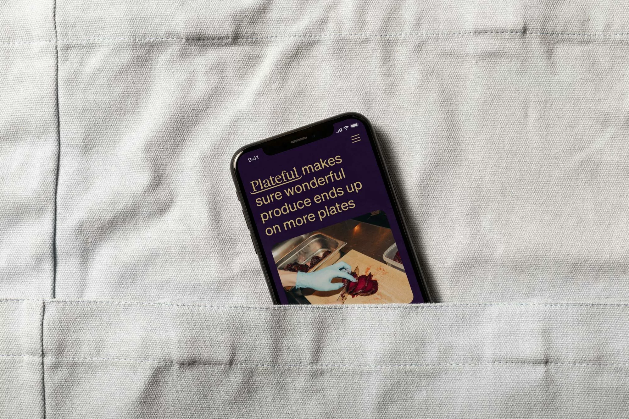 Smartphone displaying a food preparation scene rests in a white shirt pocket, showcasing a modern blend of technology and culinary arts.