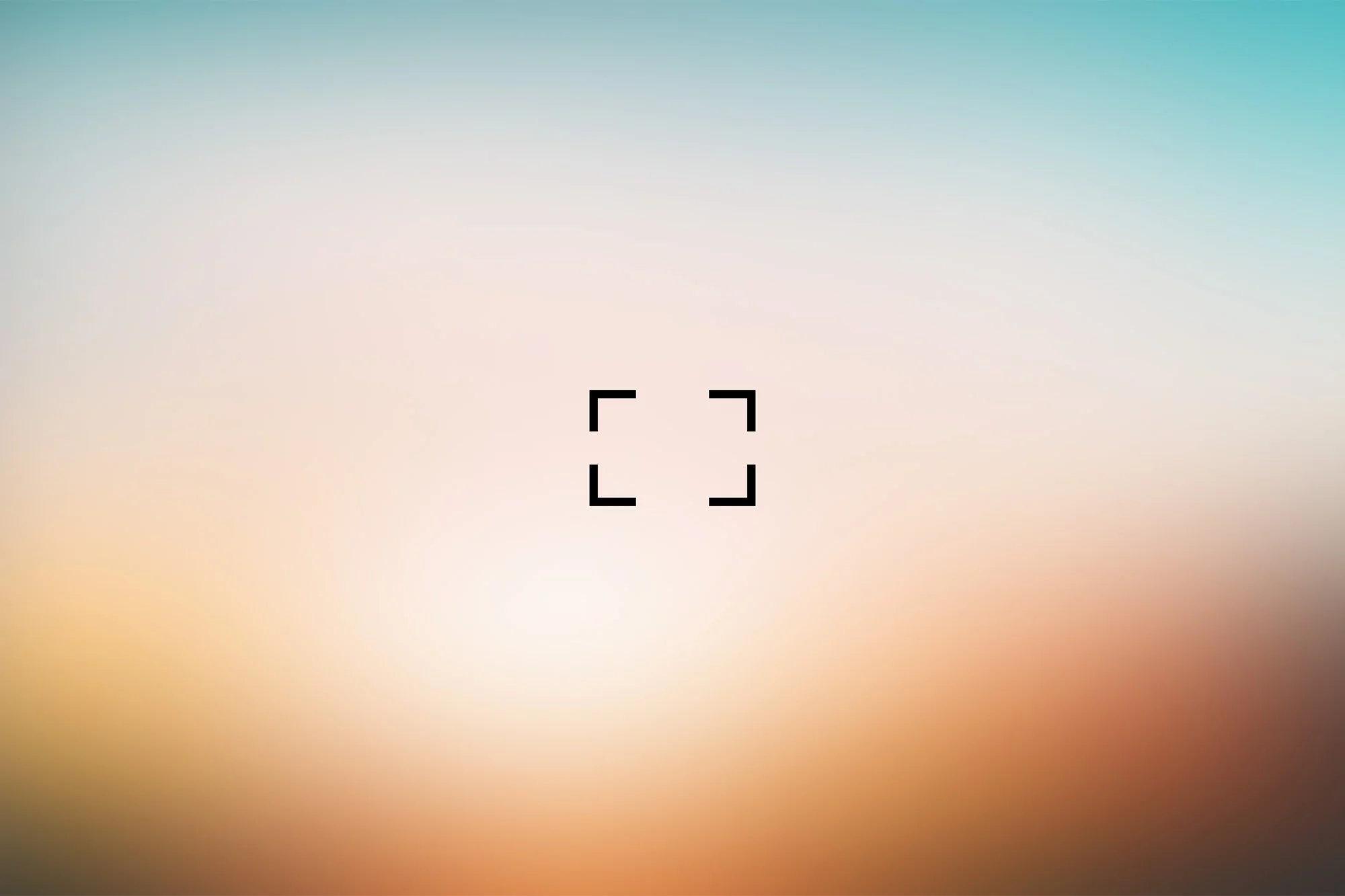 Blurred gradient background with a square focus reticle in the center, blending soft tones of orange, white, and light blue in a smooth gradient.