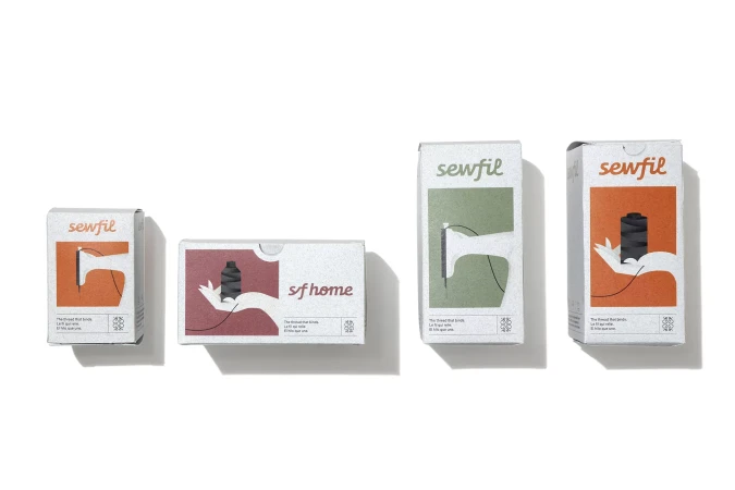 Four differently sized boxes of Sewfil thread are lined up against a white backdrop, each bearing unique graphic designs and color palettes.