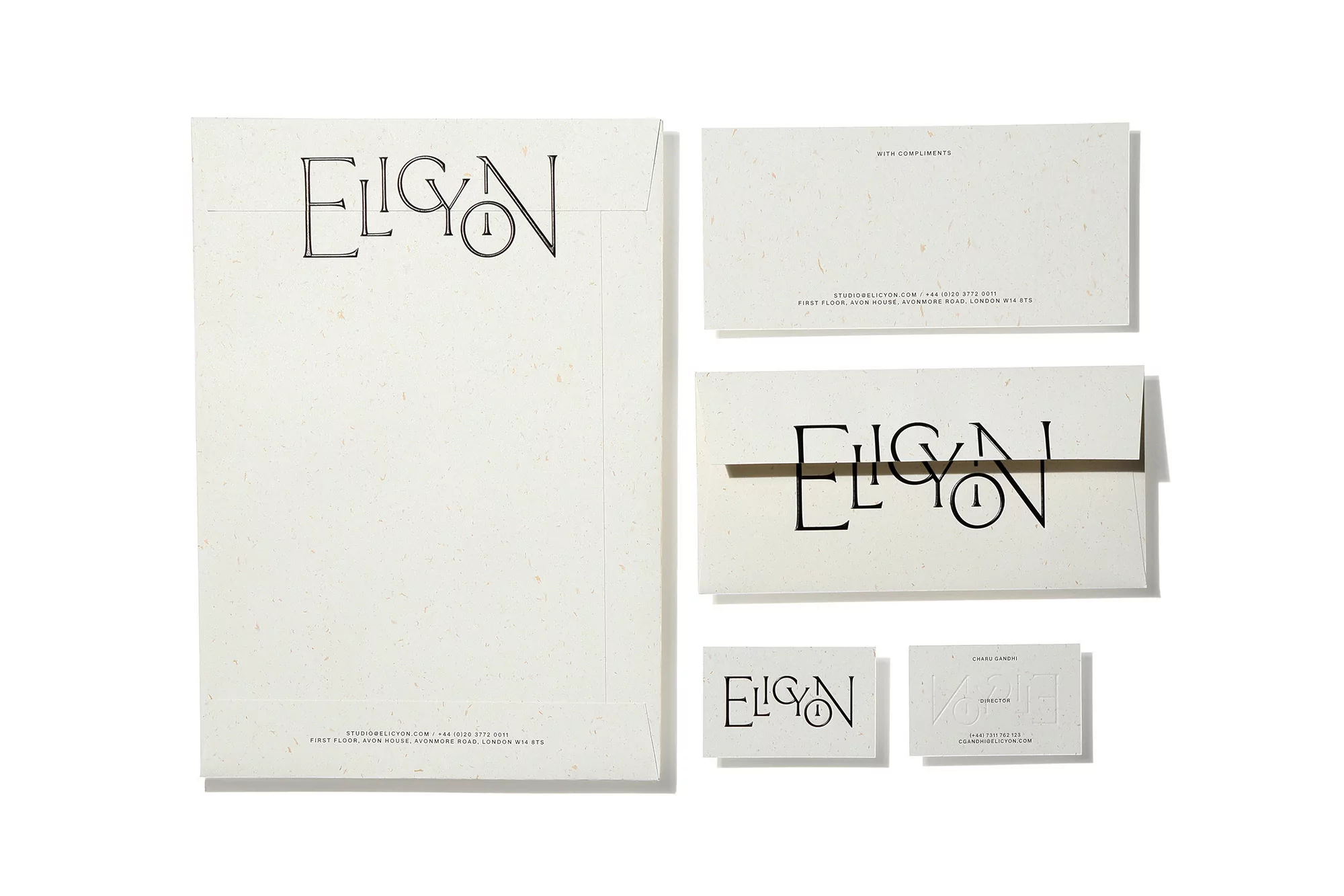 Elevated view of Eligon branded stationery including envelopes, cards, and letterhead on a white background. The brand name is in black text.