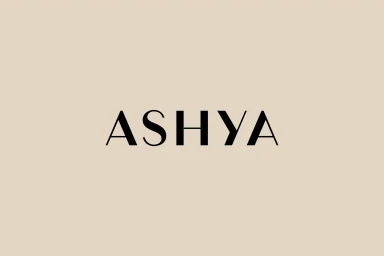 ASHYA brand logo in black serif typography centered on a solid beige background