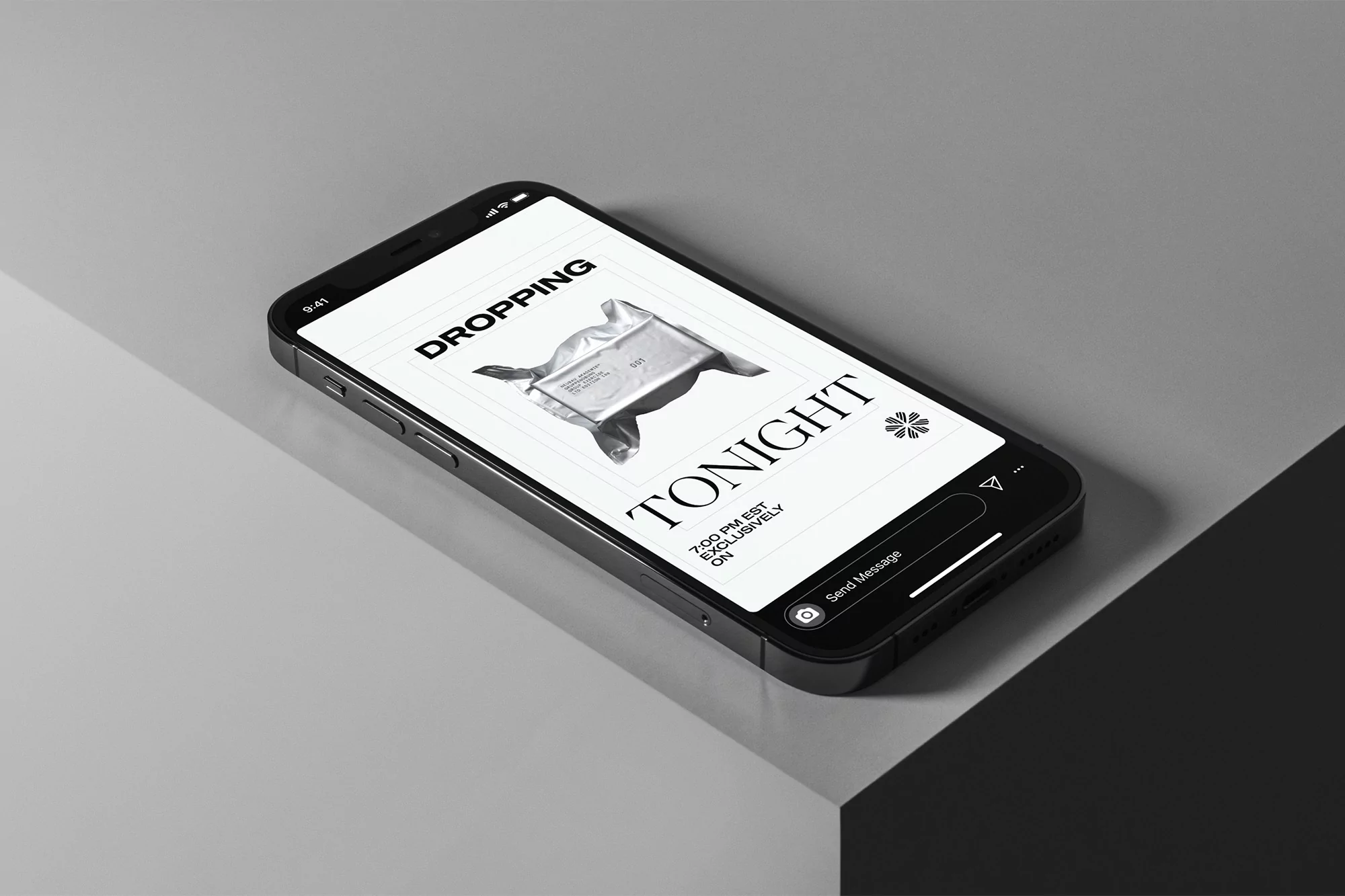 Black smartphone displaying ad of silver wrapped product and typography “Dropping Tonight,” rests on stepped grey surface.