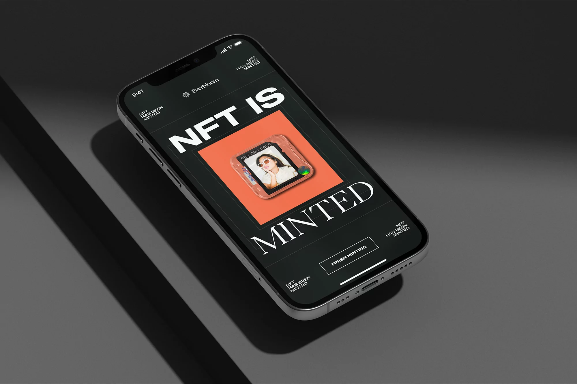 Silver iPhone on a gray surface displaying 'NFT is Minted' with a portrait NFT and brand logo 'Everbloom' under studio lighting.