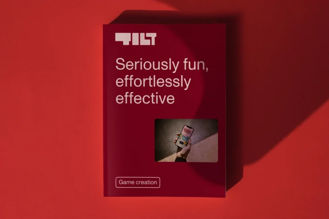 Promotional poster on a red background shows a mobile phone game app for Tilt; it is designed to be fun, effortless, and effective.