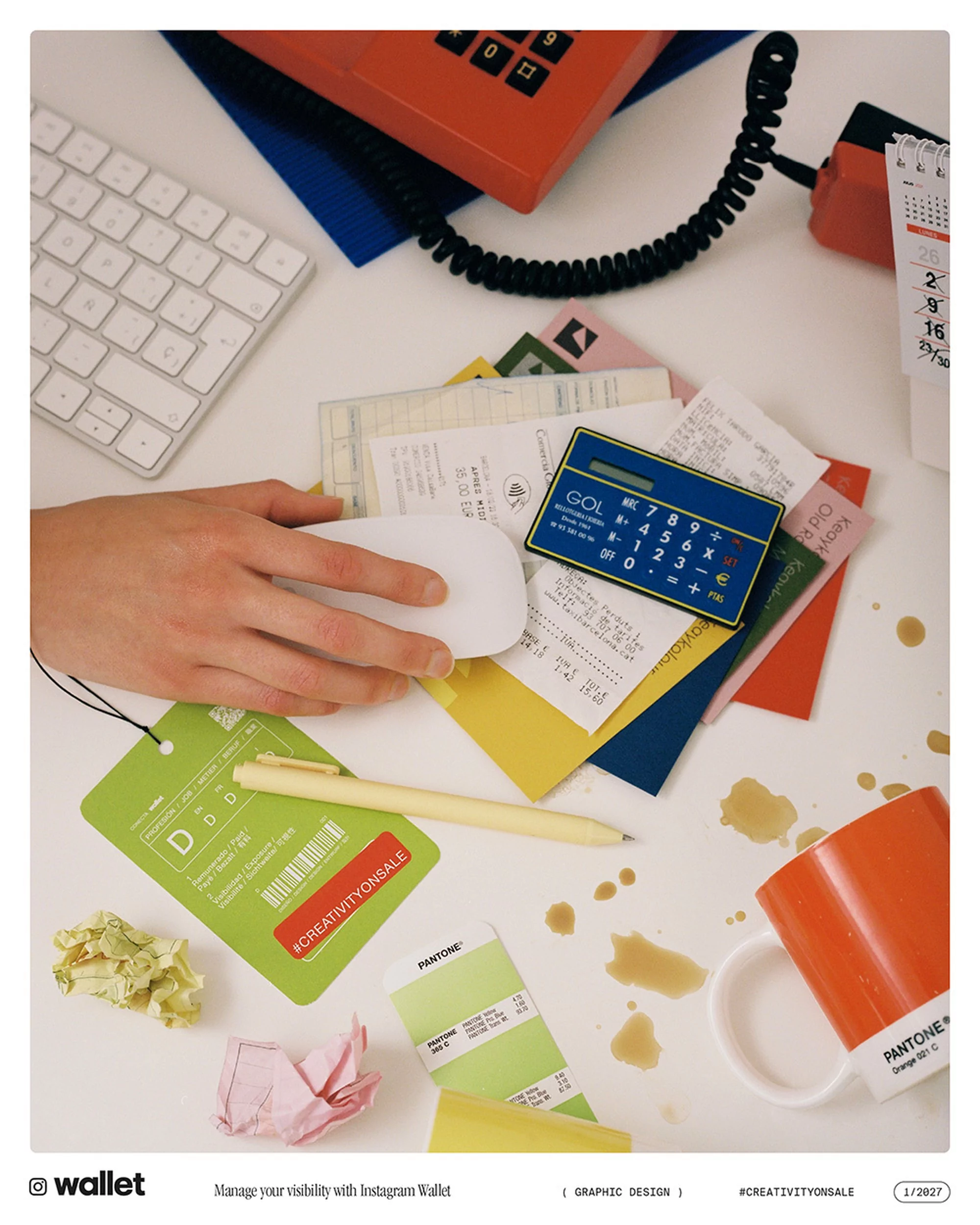 Overhead shot of a white desk with a hand, computer mouse, keyboard, telephone, calculator, receipts, crumpled paper, and spilled coffee.
