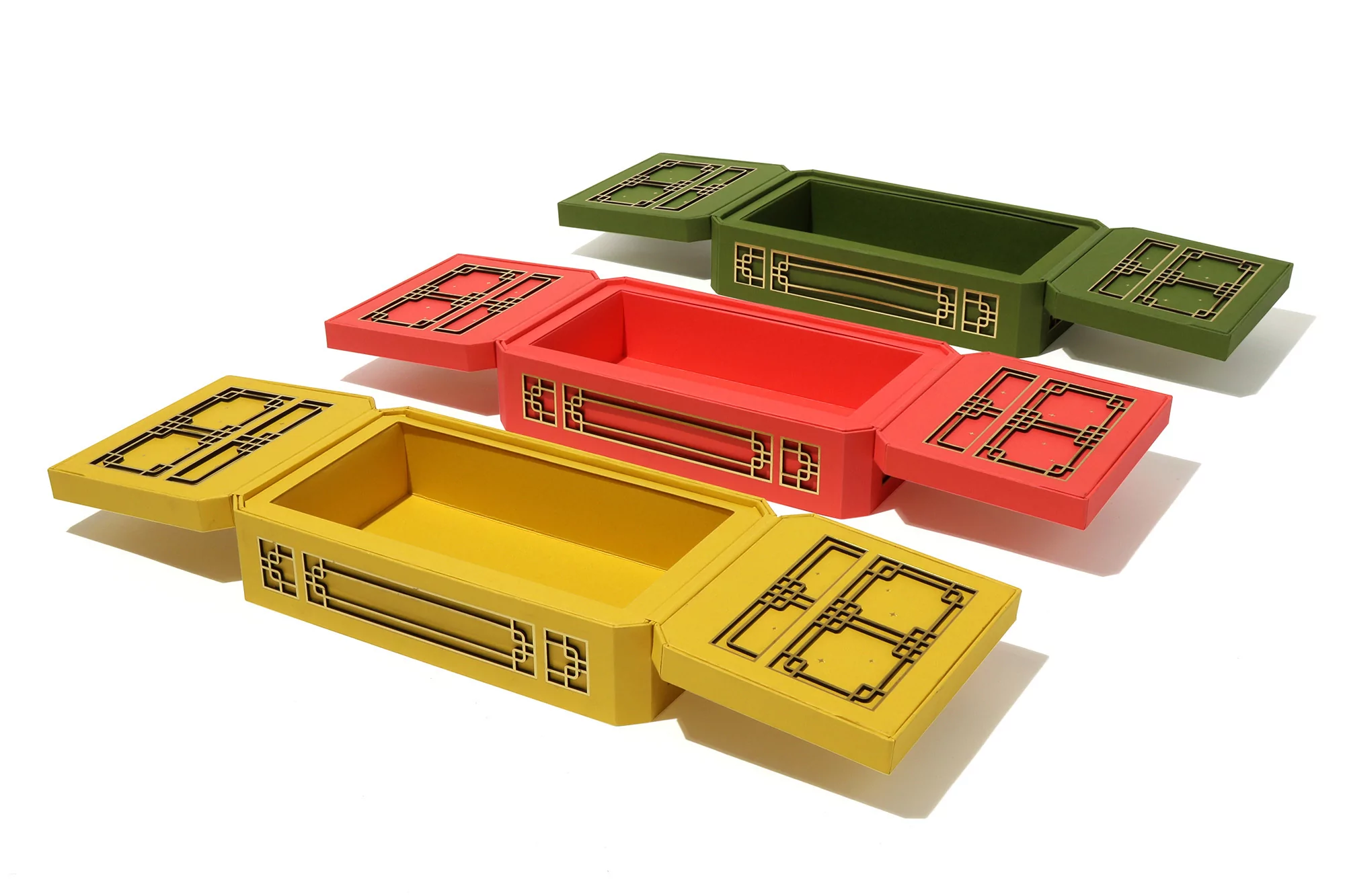 Three colorful, rectangular storage boxes with lids, arranged on a white surface, showcasing their decorative design and functionality.