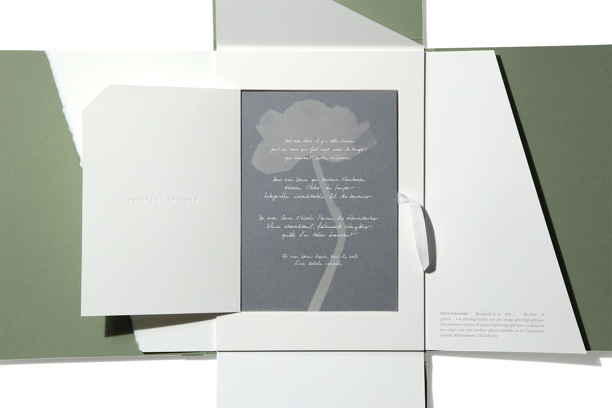 Open greeting card with a floral design and handwritten text, displayed against a green and white background, close-up view.