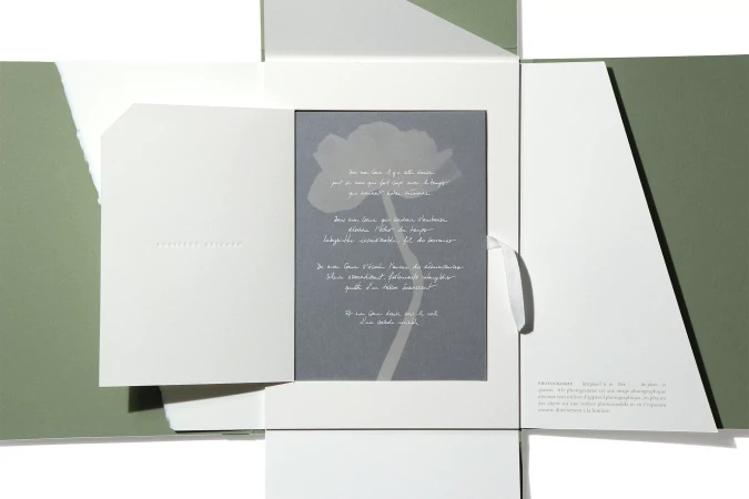 Open greeting card with a floral design and handwritten text, displayed against a green and white background, close-up view.